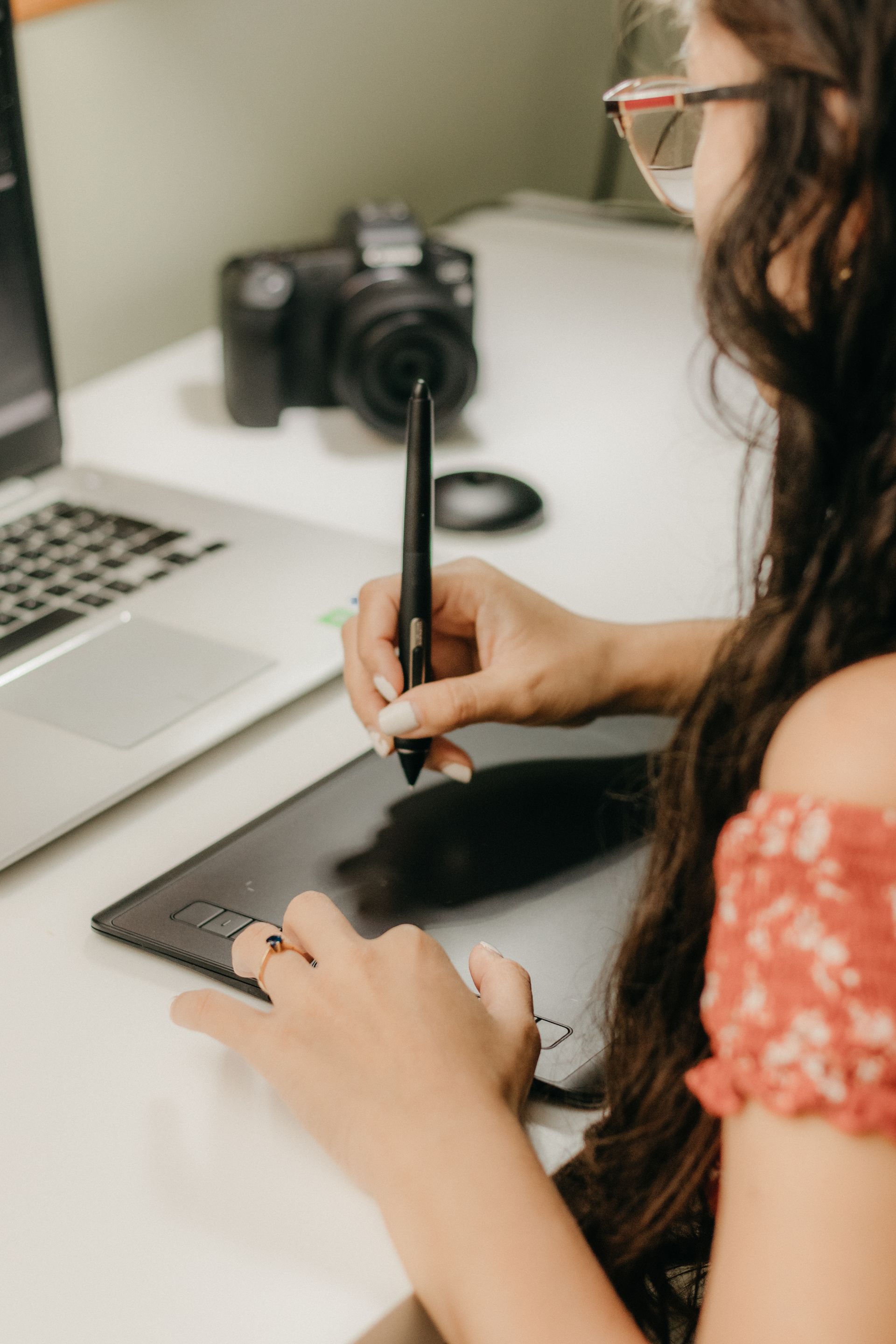 Designer working with a graphics tablet and laptop, representing the graphic design project process