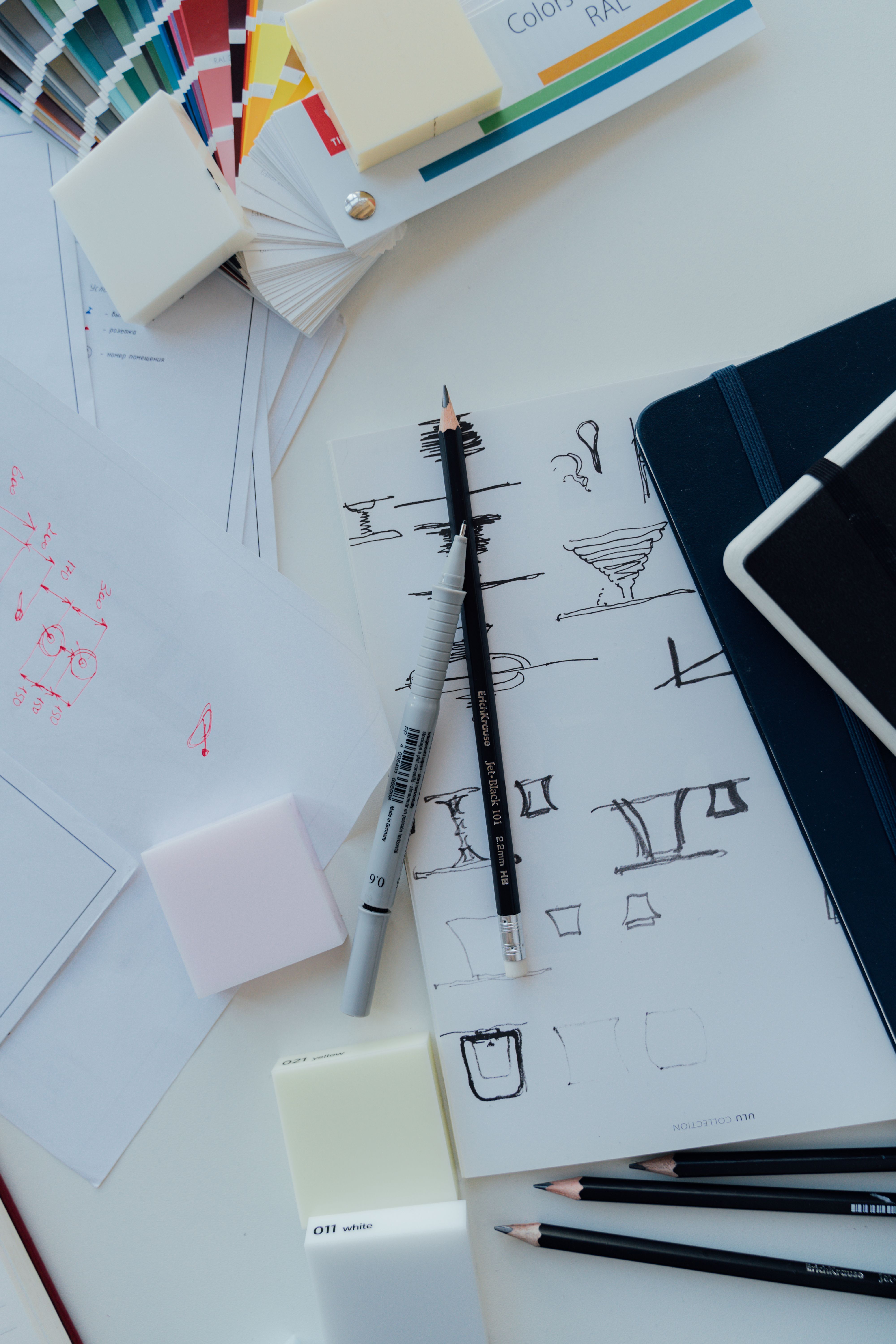 Espaço de trabalho criativo com esboços, amostras de cor e ferramentas de design sobre a mesa